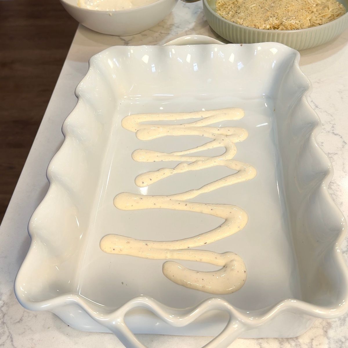 white casserole dish with caesar dressing on bottom of dish