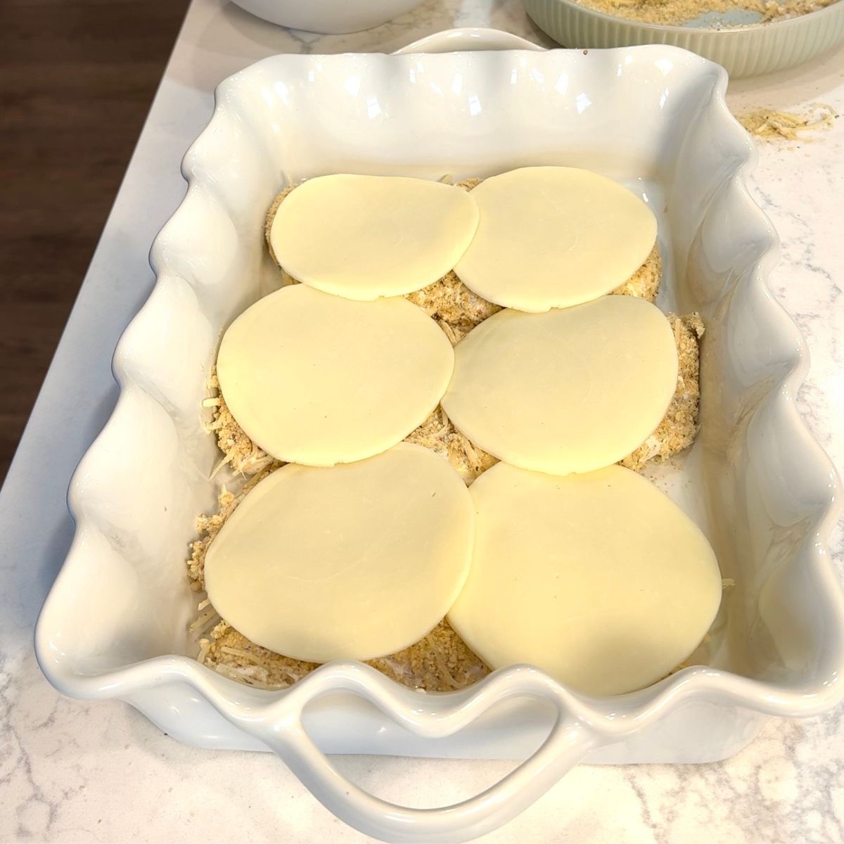 provolone cheese on top of chicken caesar chicken bake in casserole dish