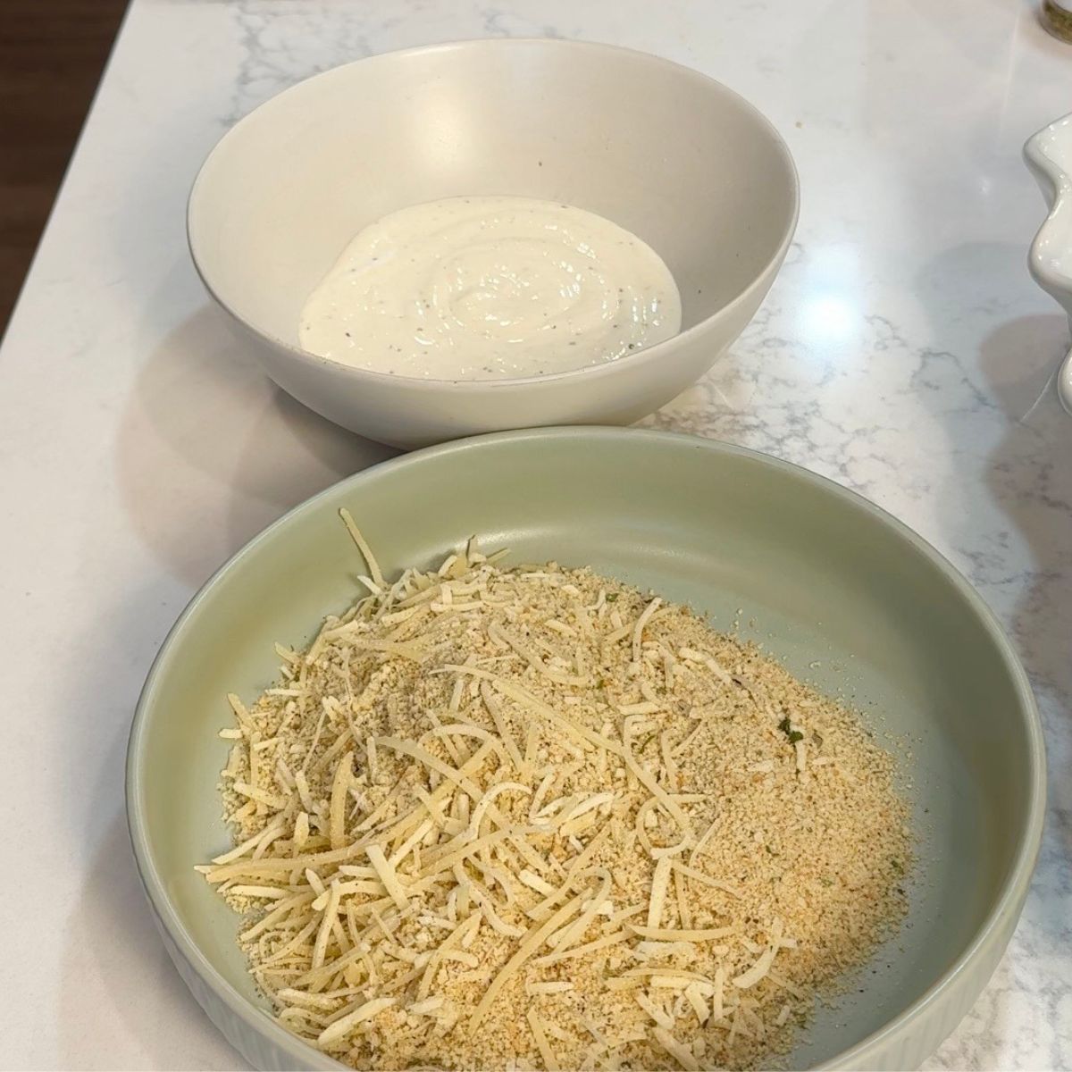 caesar dressing in white bowl and breadcrumbs in green bowl