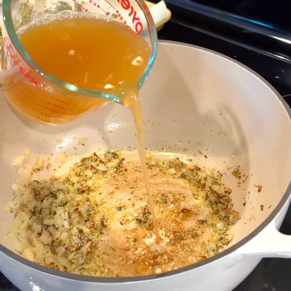 chicken broth added to large pot with seasonings 