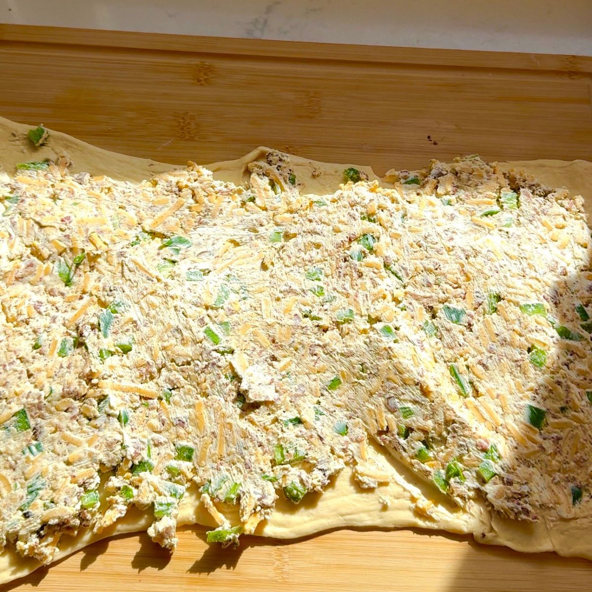 jalapeno popper mixture spread on crescent dough