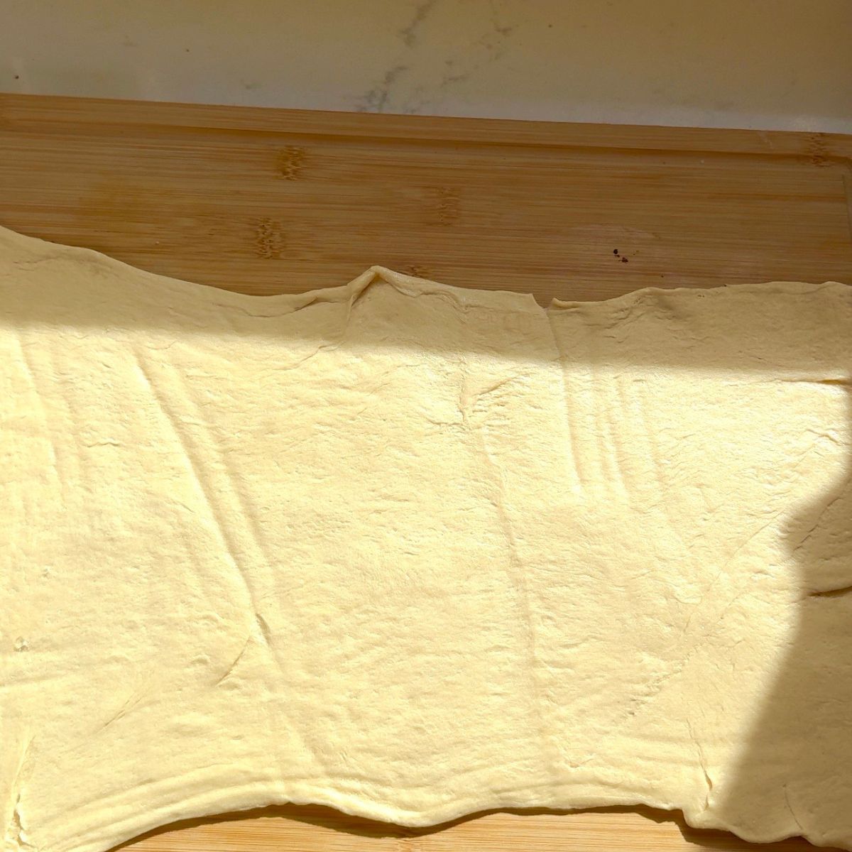 crescent dough laying flat on wooden board