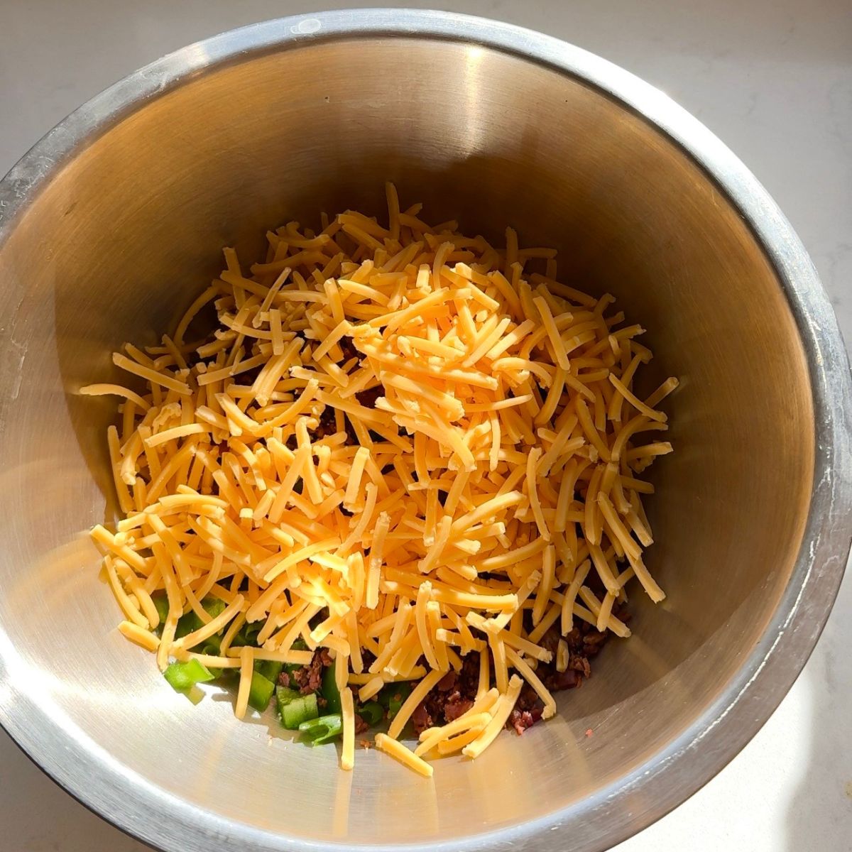 recipe ingredients in mixing bowl with cheese on top