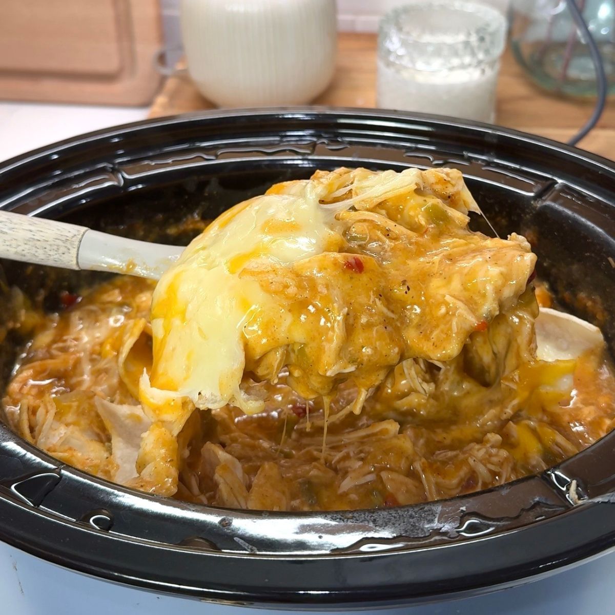 chicken, cheese and tortillas in enchilada sauce in slow cooker