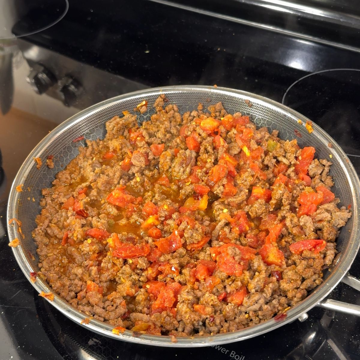ground beef and tomatoes in skillet