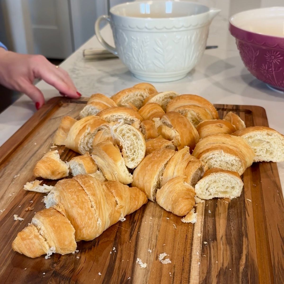 Sliced bread on wooden board with bowls in background