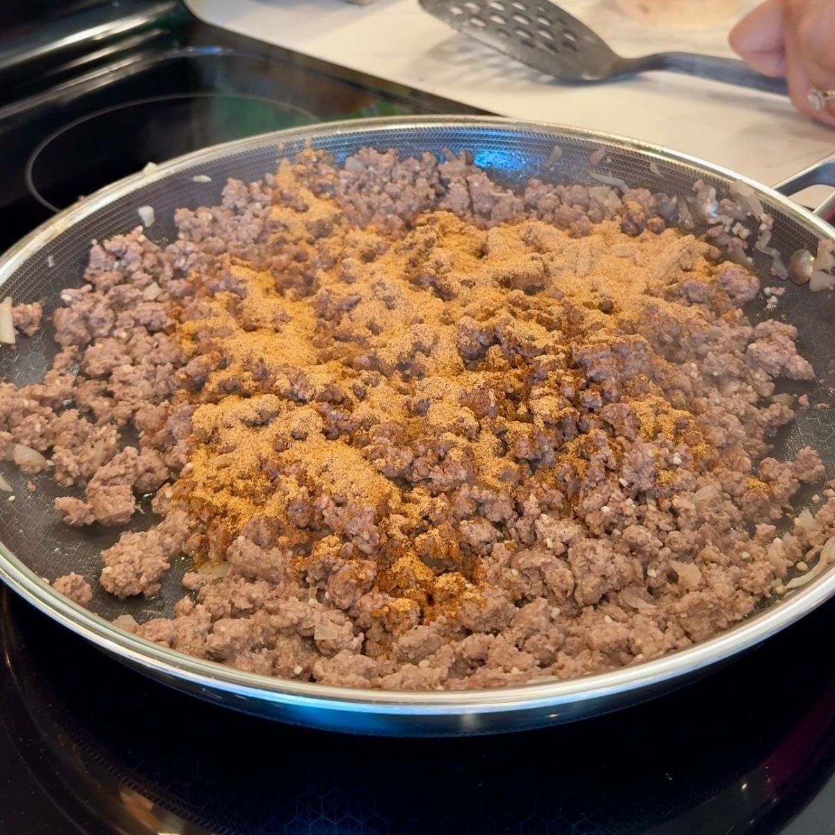 taco seasoning added to meat in pan