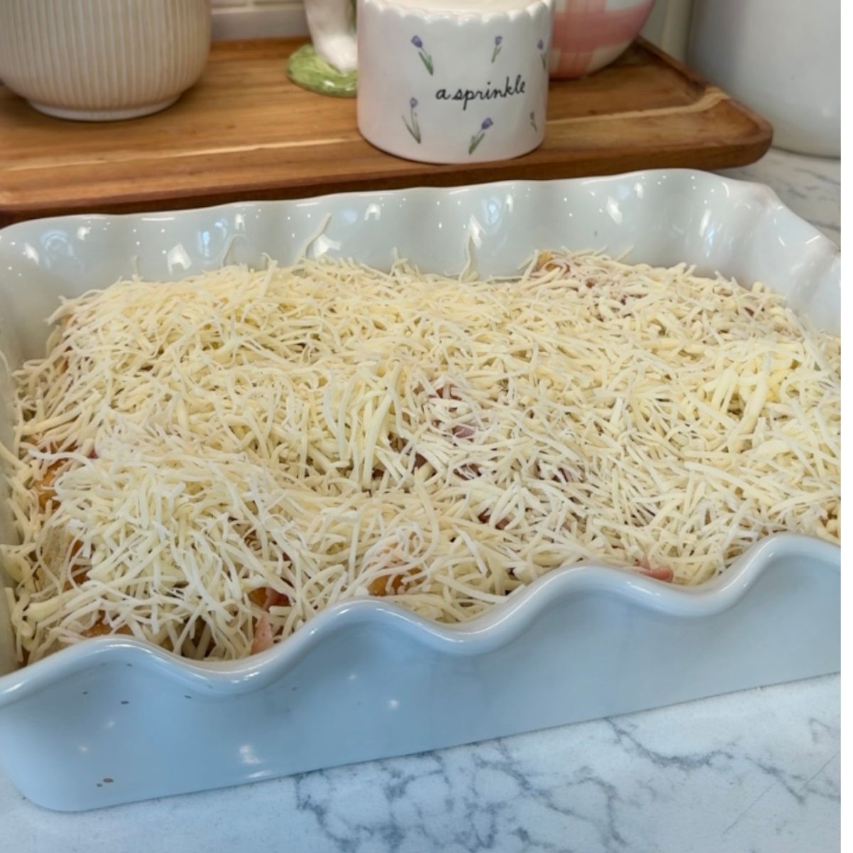 white cheese added on top of ham and egg mixture for breakfast bake