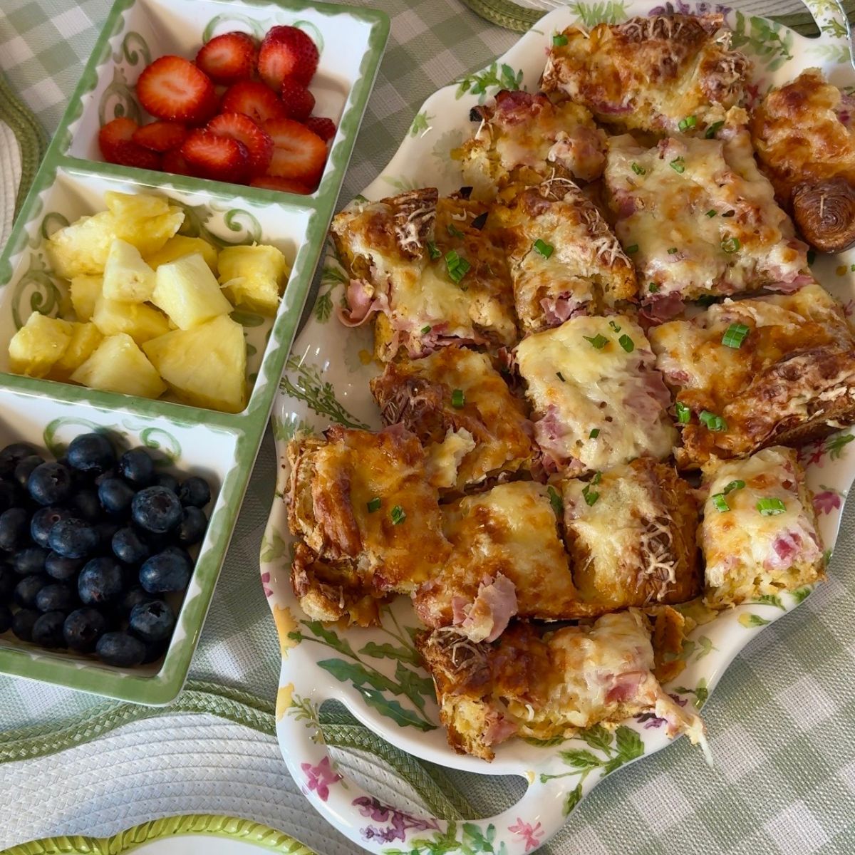 ham egg and cheese croissant casserole on plate with fruit on side for breakfast