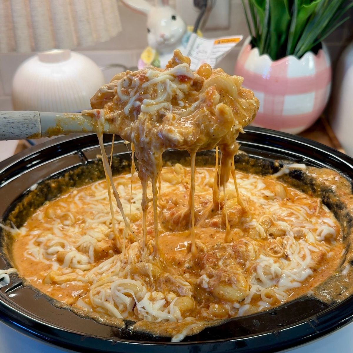 slow cooker chicken pasta in crockpot with pasta in spoon 