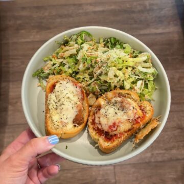 chicken parmesan texas toast with caesar salad on green plate