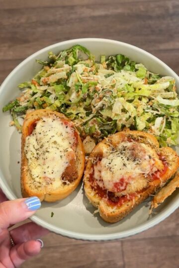 chicken parmesan texas toast with caesar salad on green plate