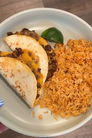 easy baked beef tacos with rice and lime wedge on green plate