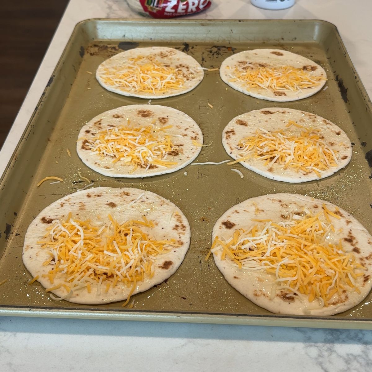 cheese on tortillas on baking tray