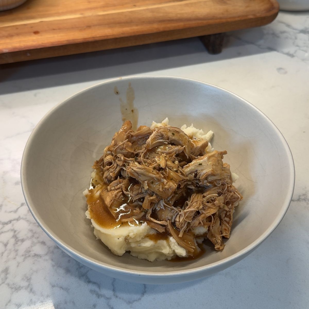 slow cooker mississippi chicken over potatoes in bowl