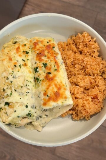 salsa verde chicken enchiladas with rice on green plate