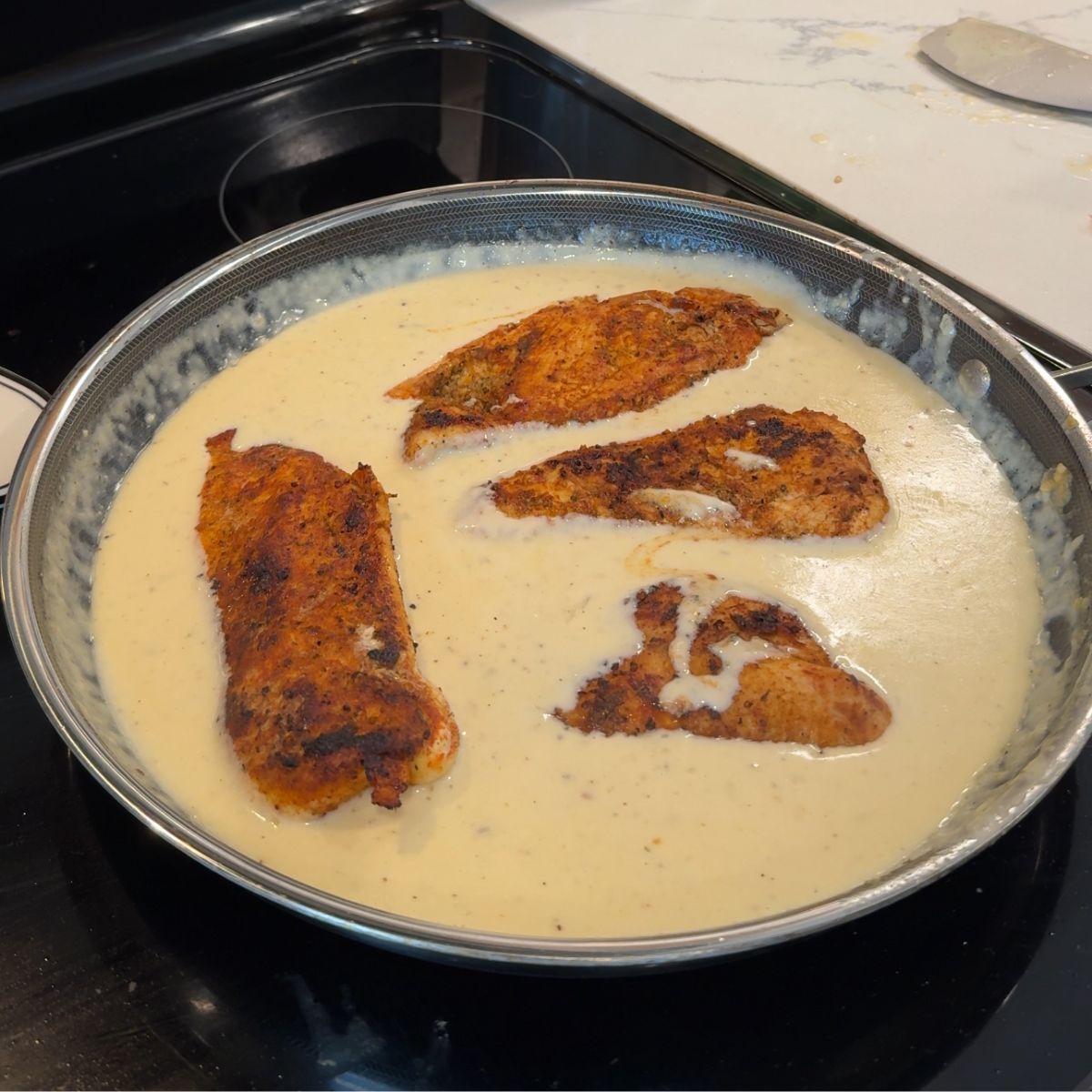 chicken in cream sauce on pan 