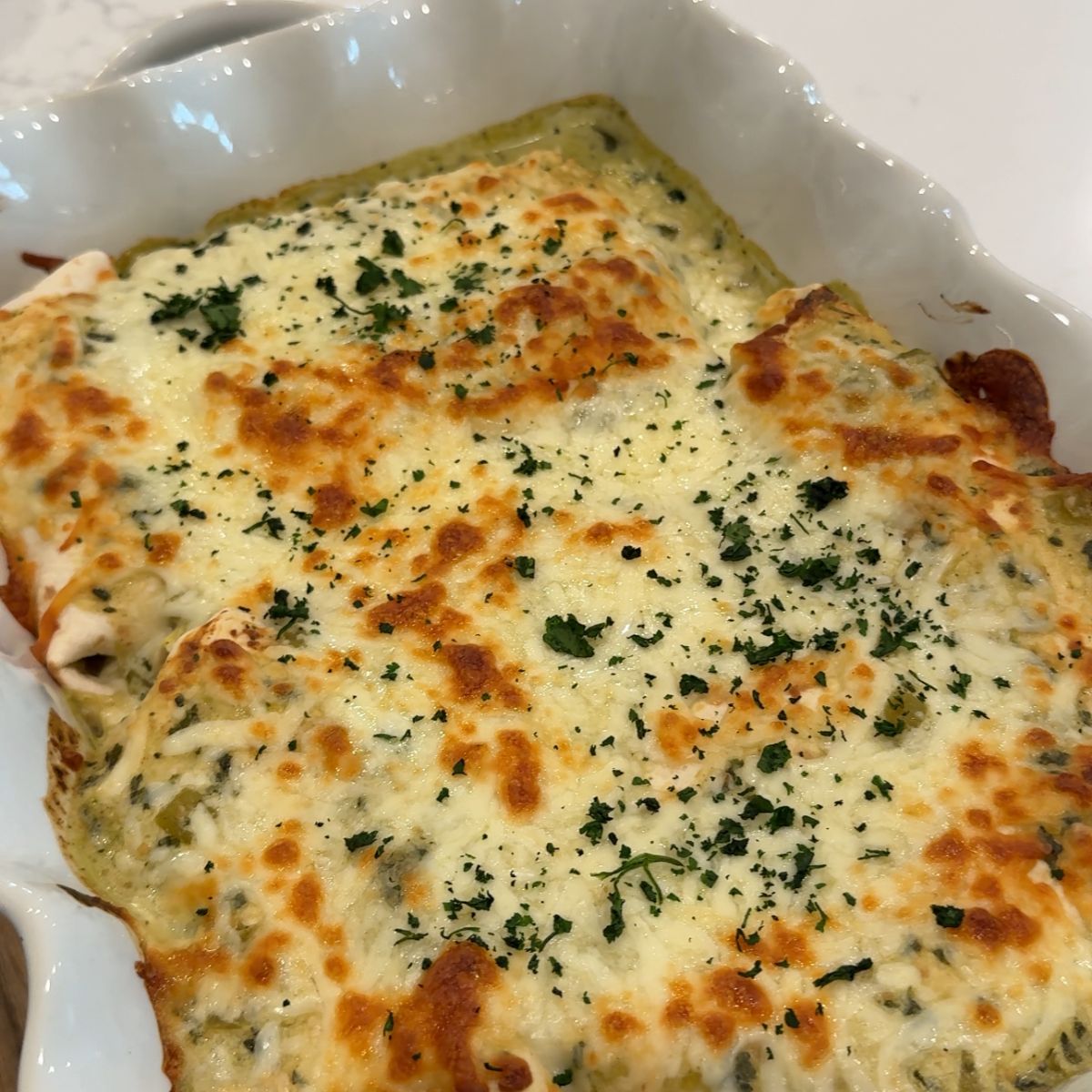 chicken enchiladas with melted cheese in casserole pan