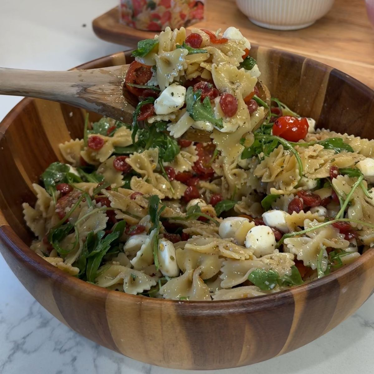 hot honey pizza pasta salad in bowl with spoon holding pasta 