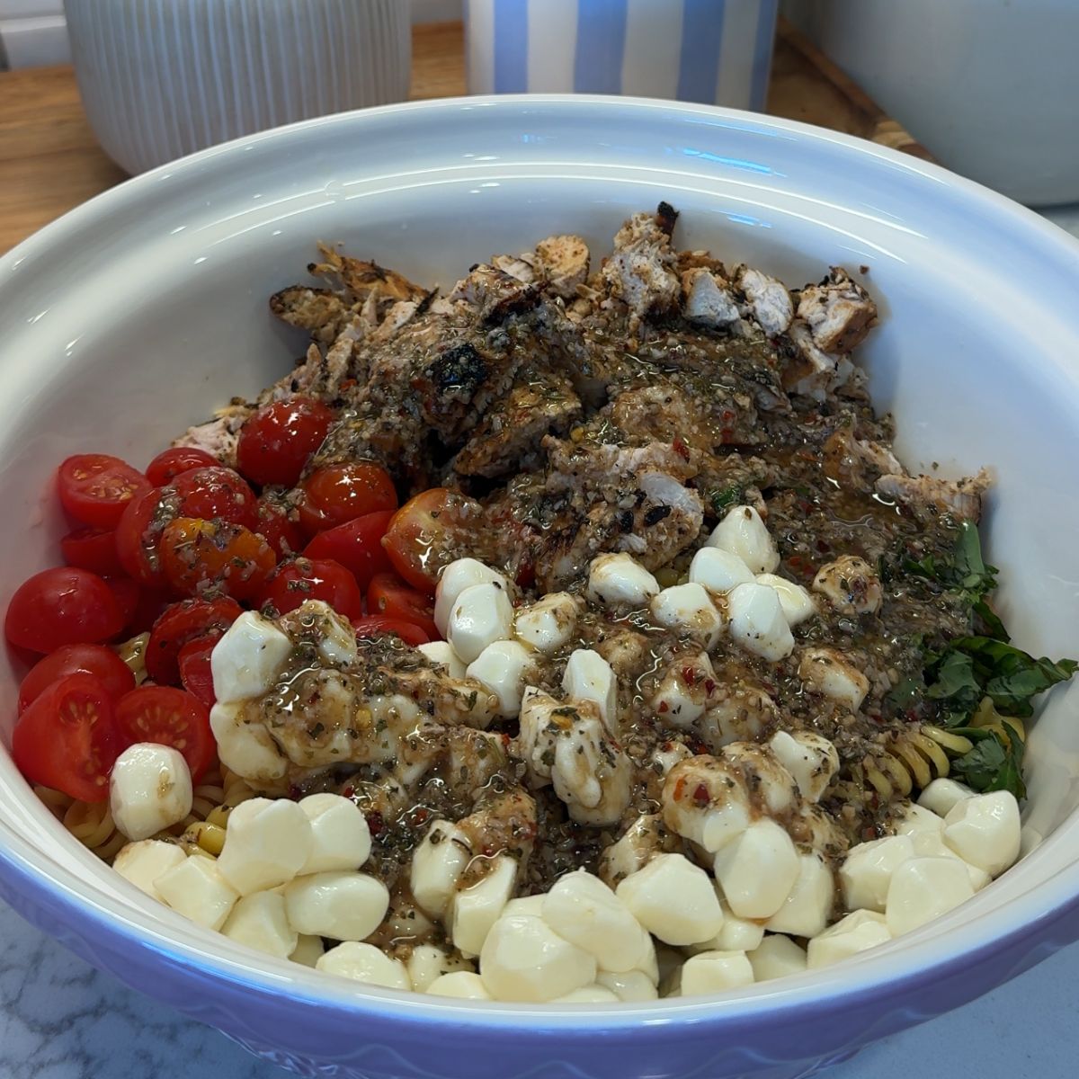 balsamic dressing on top of tomatoes, chicken, basil, and mozzarella