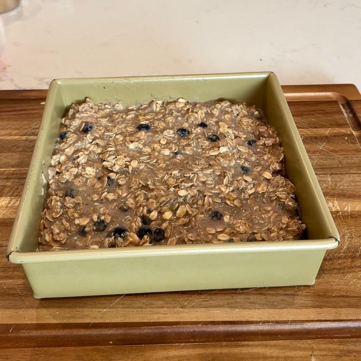 baked oatmeal in baking tray on top of wooden board