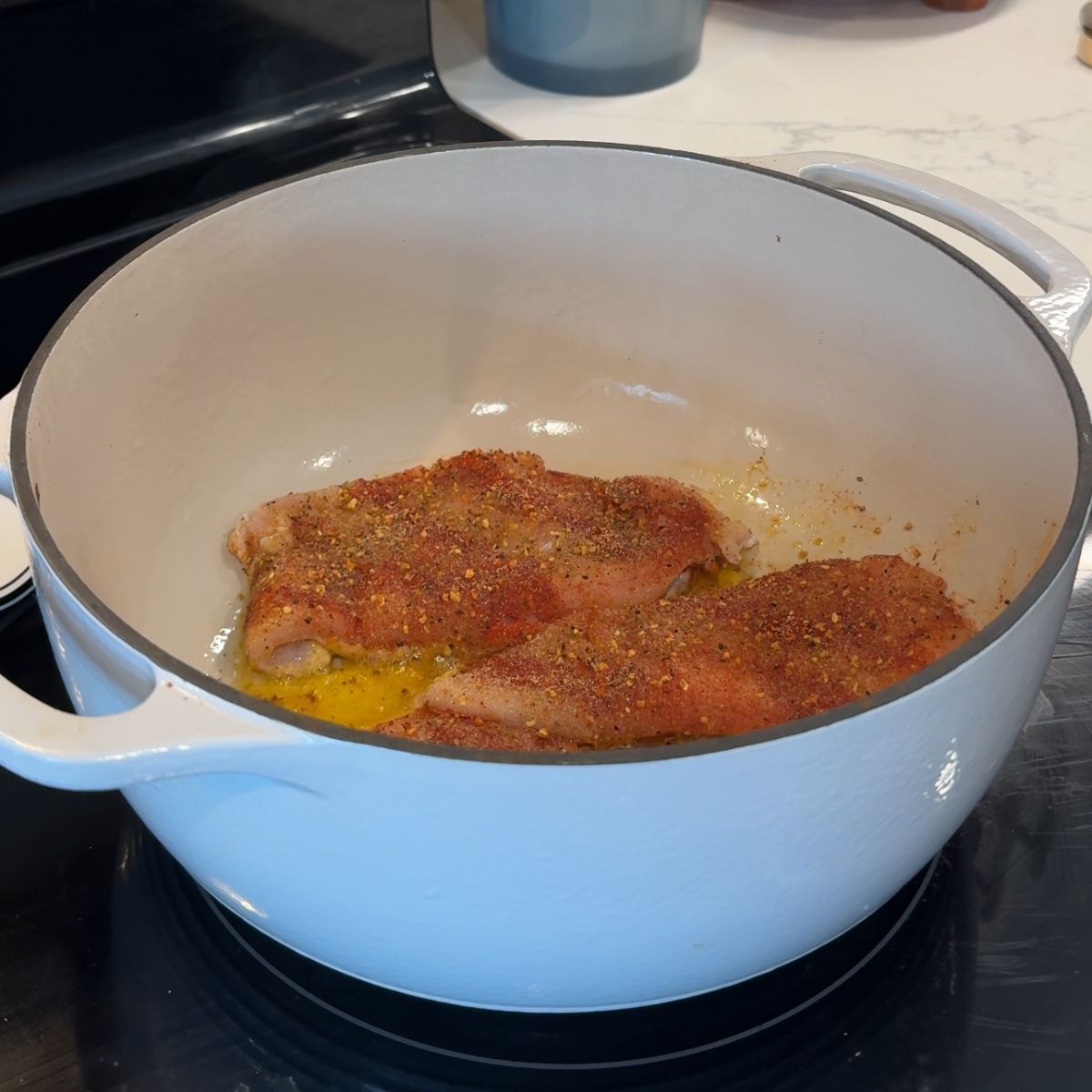 chicken in white pot cooking on stove