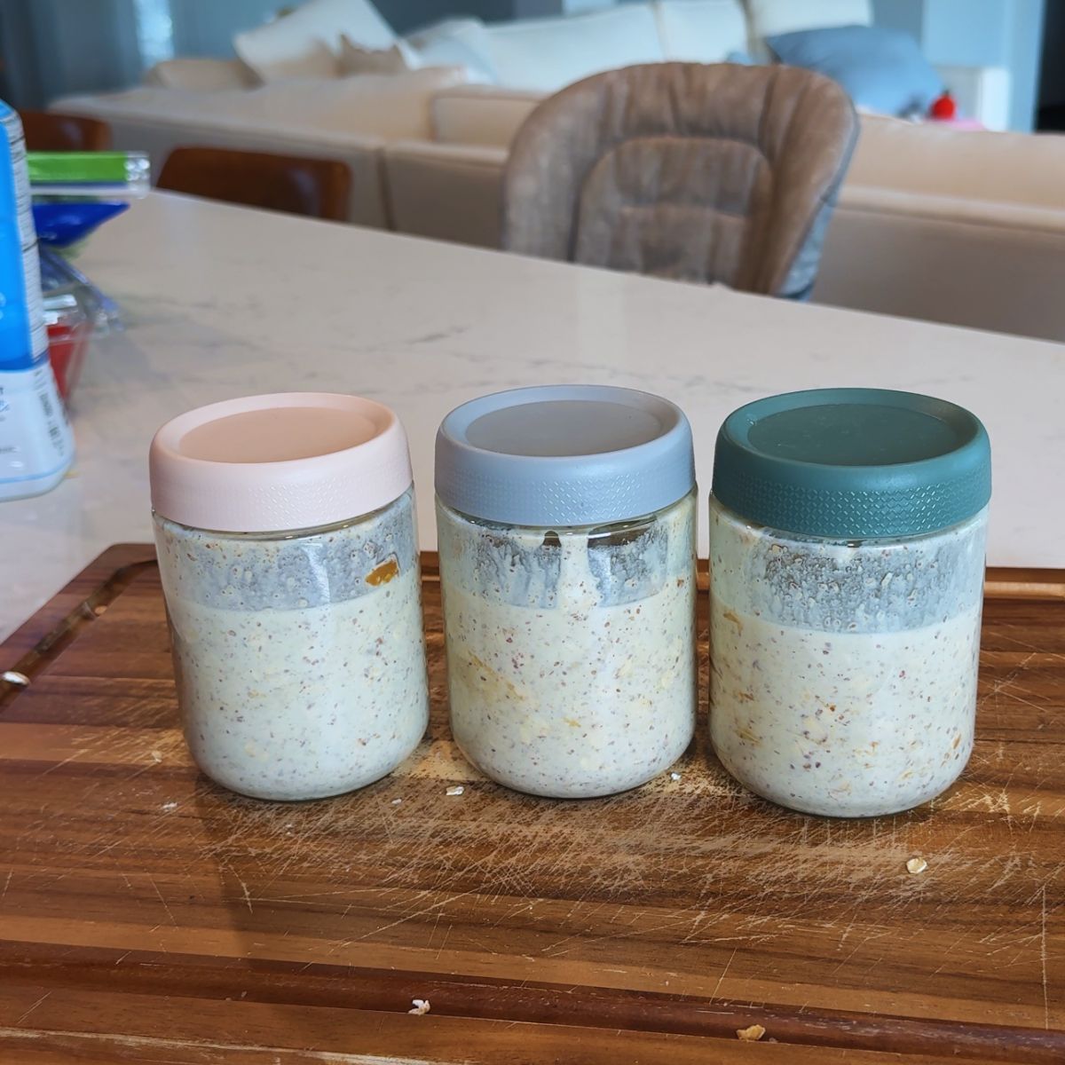 3 jars with cookie butter overnight oats on wooden board
