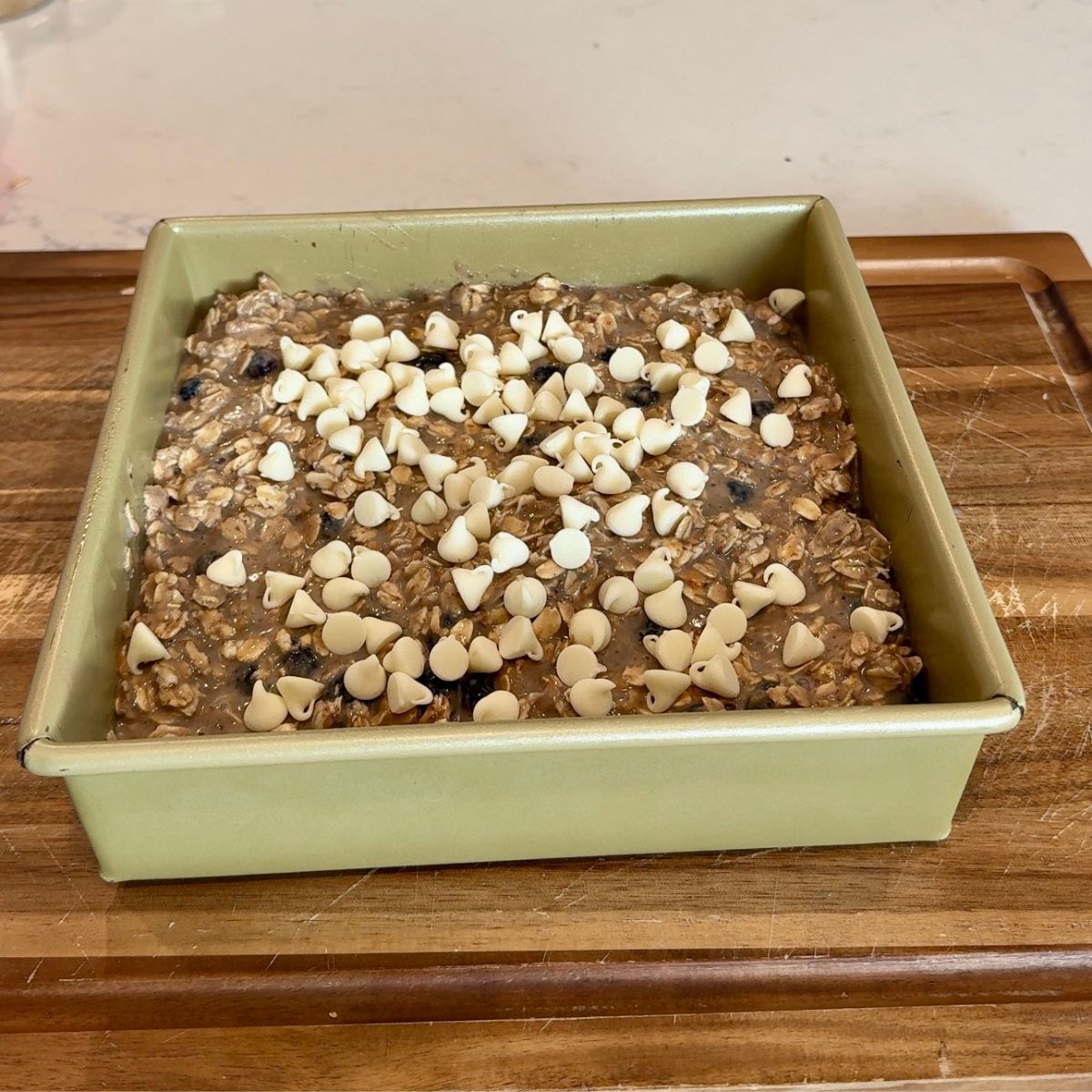 white chocolate chips on top of breakfast bake in pan on wooden board