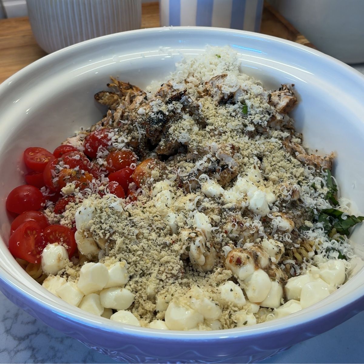 bread crumbs, cheese, tomatoes, chicken, basil in bowl