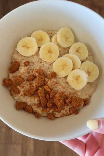 cookie butter overnight oats with biscoff cookies and banana in bowl in hand