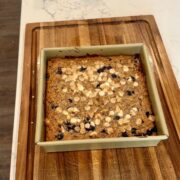 blueberry baked oatmeal in pan with wooden board underneath