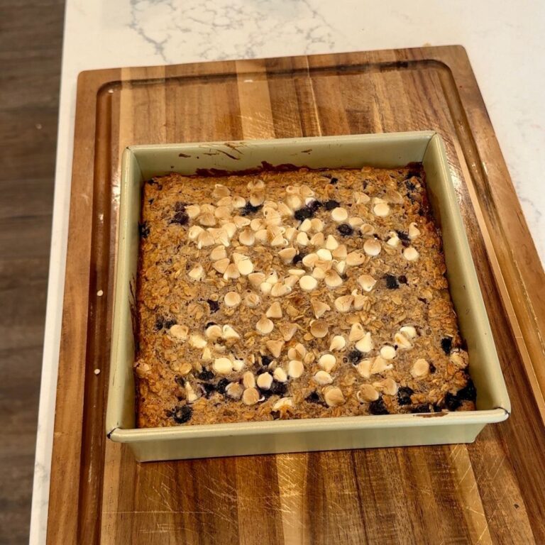 blueberry baked oatmeal in pan with wooden board underneath