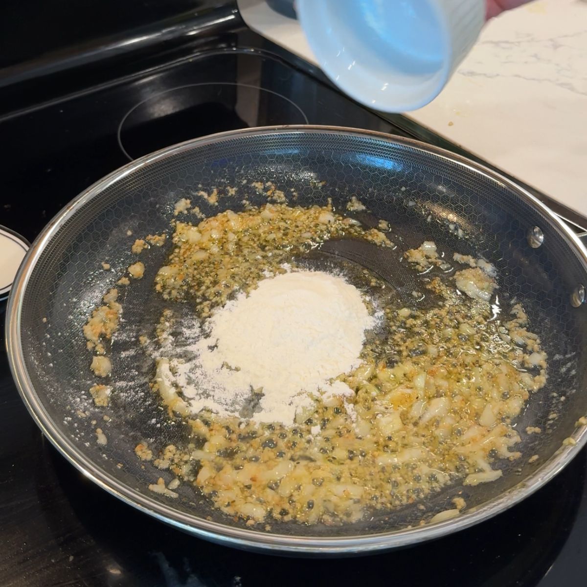 flour on skillet with garlic, onion and butter. 