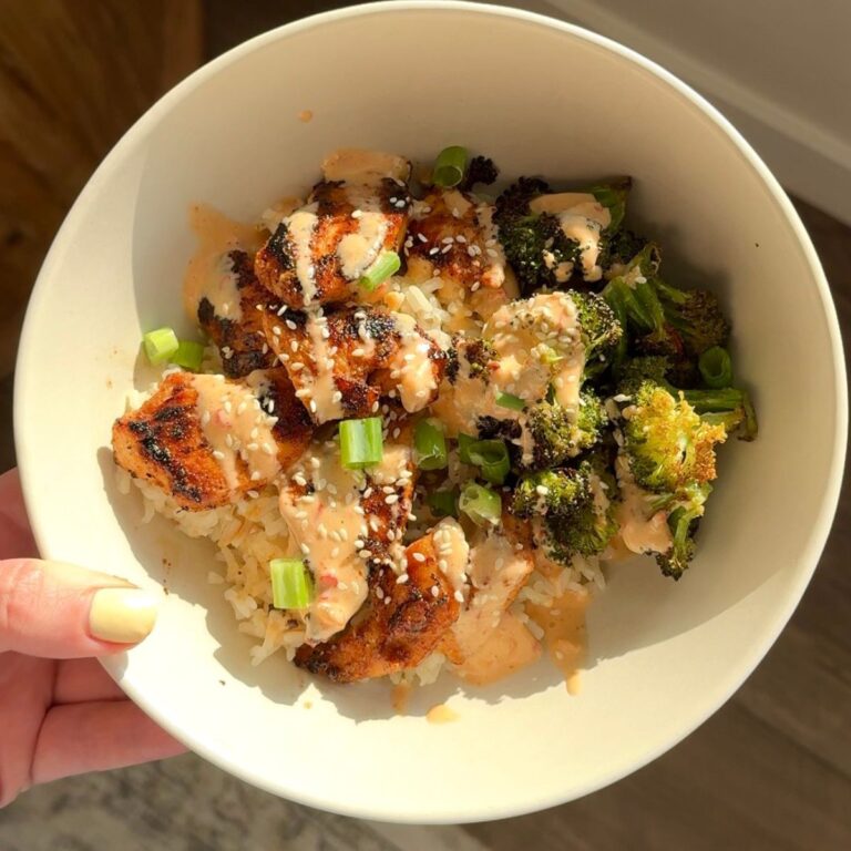 bang bang chicken with broccoli and rice in bowl and hand holding bowl