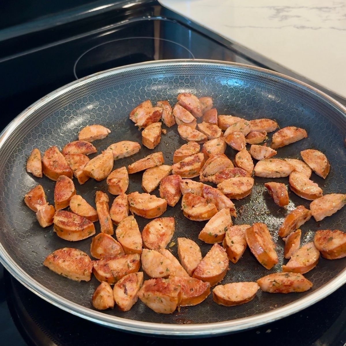 sliced chicken sausage in skillet