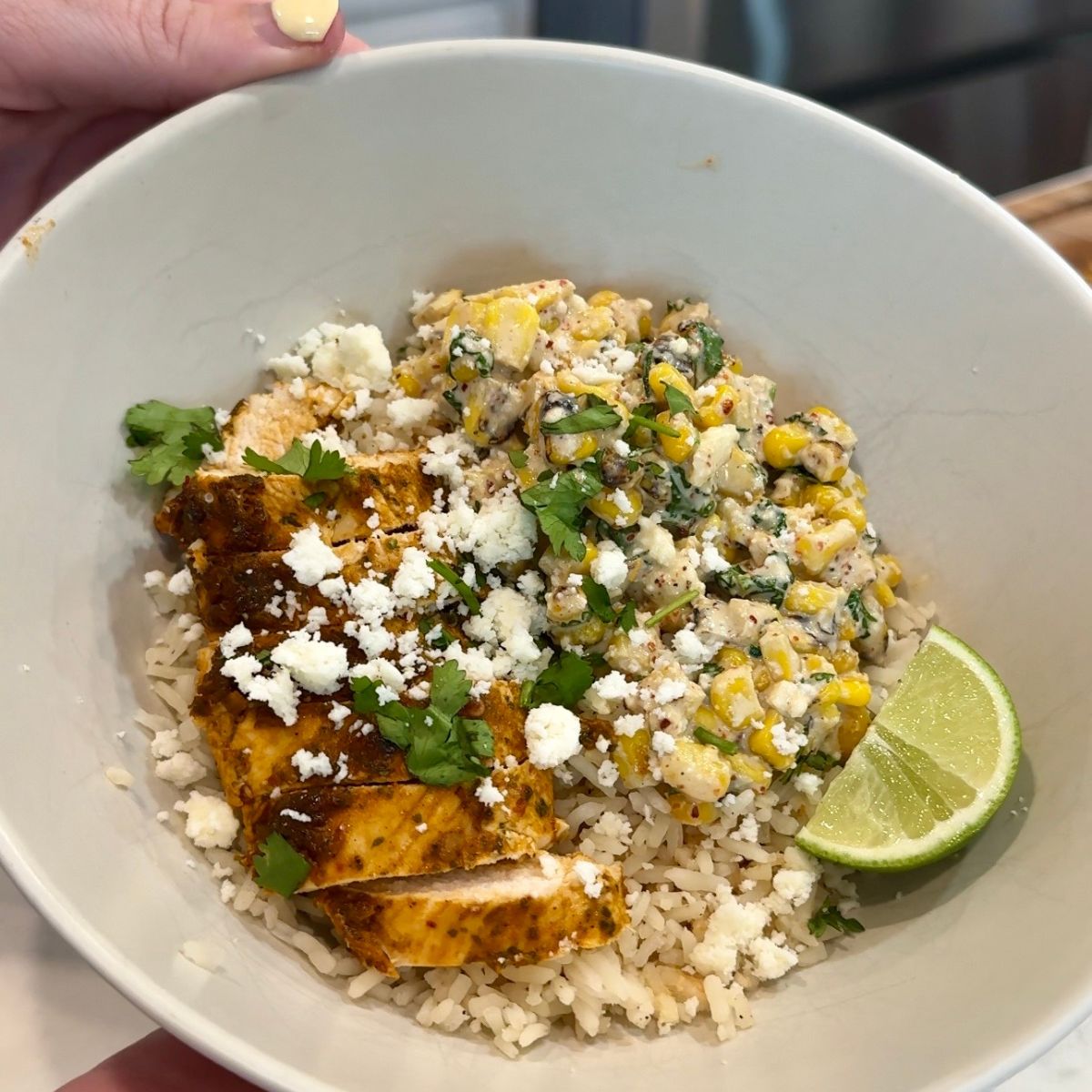 chicken street corn bowls with rice and lime wedge in bowl