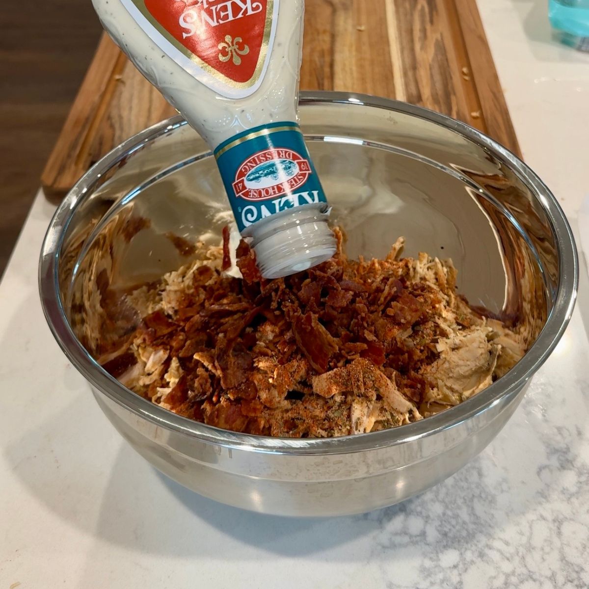 ranch dressing bottle over chicken mixture in bowl