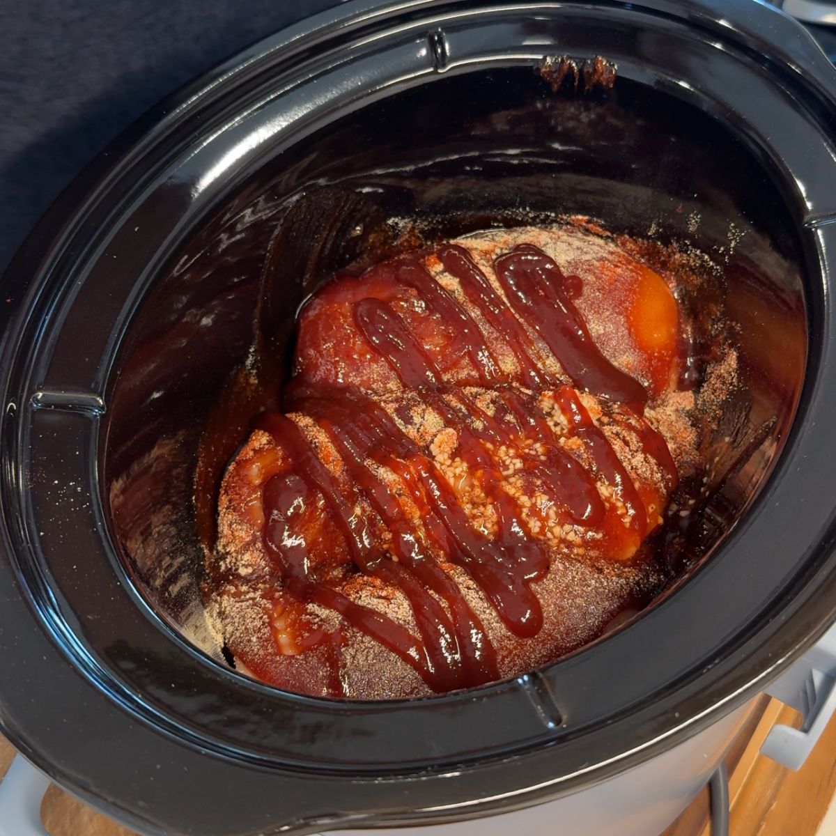 chicken with bbq sauce, seasonings in slow cooker