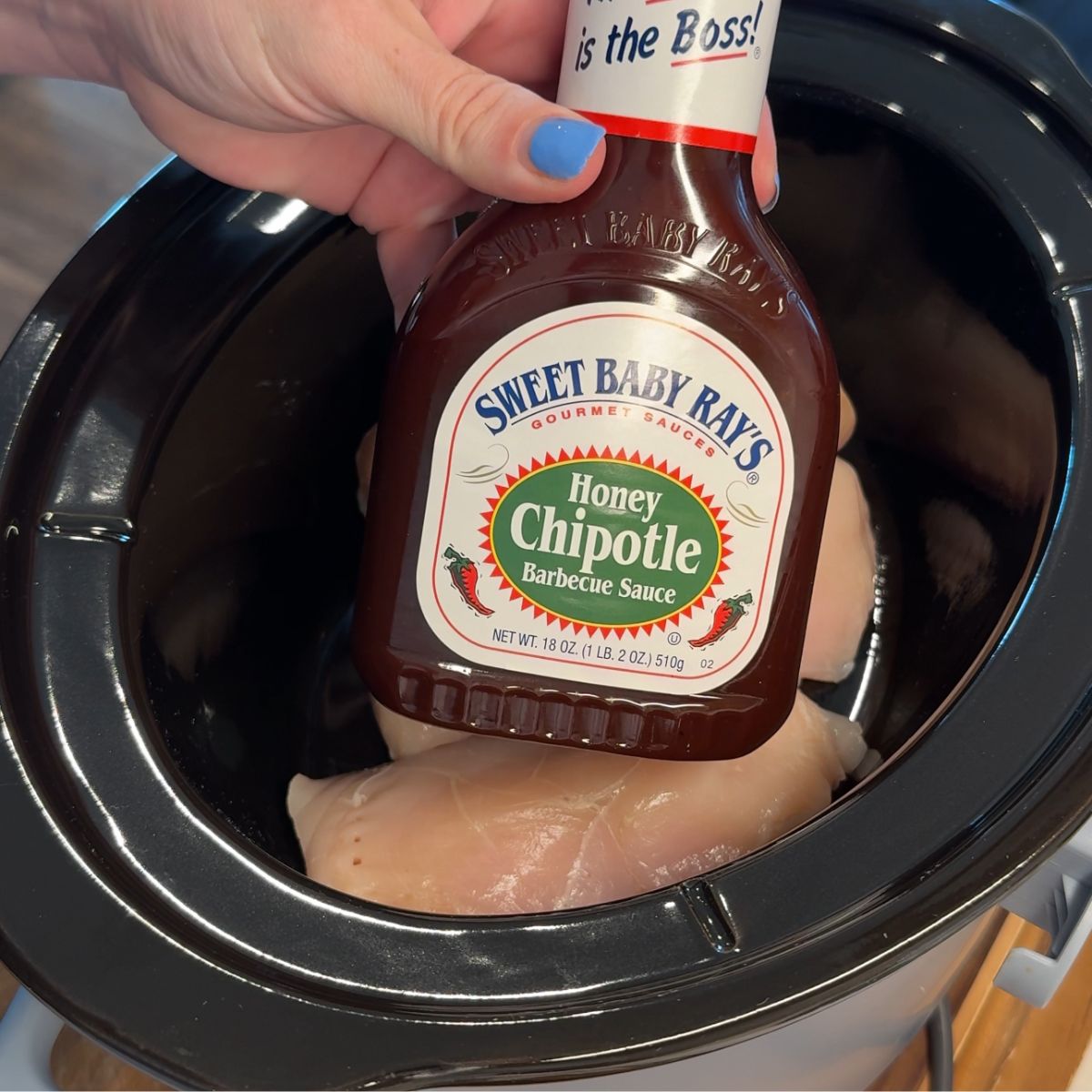 sweet baby rays honey chipotle sauce bottle over slow cooker with chicken