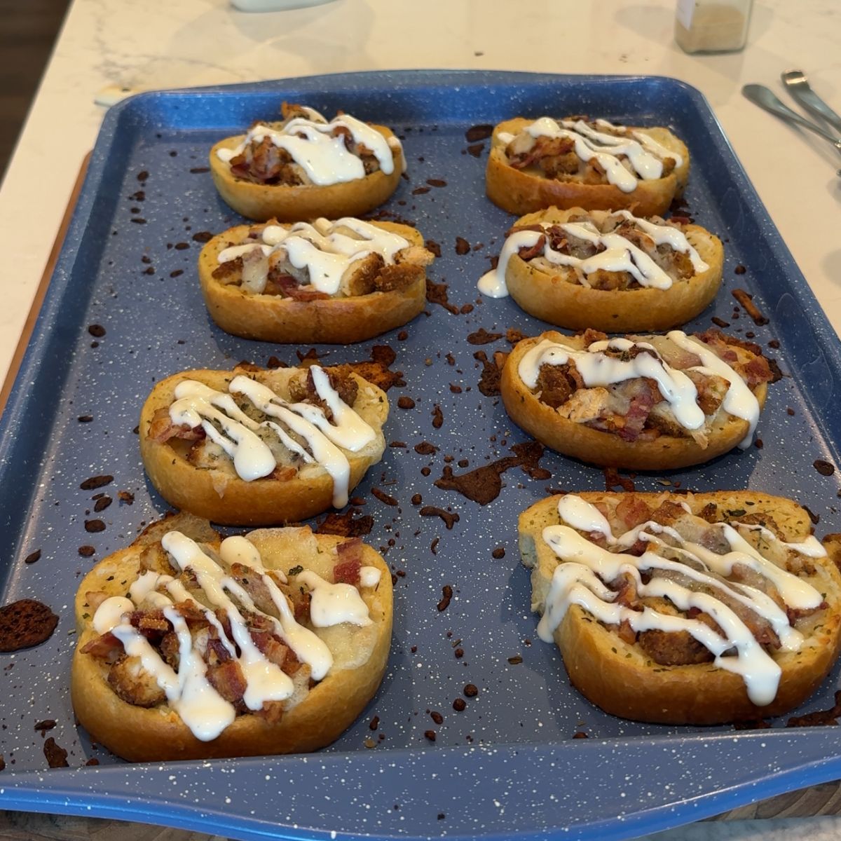8 chicken bacon ranch texas toast on blue baking sheet pan