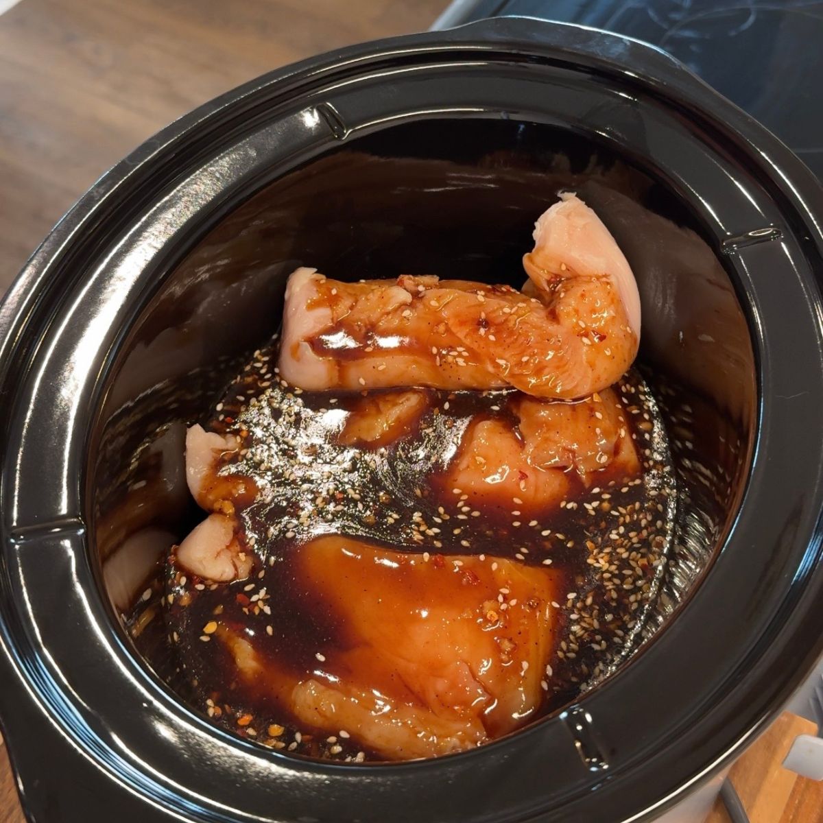 sauce mixture poured over chicken in slow cooker