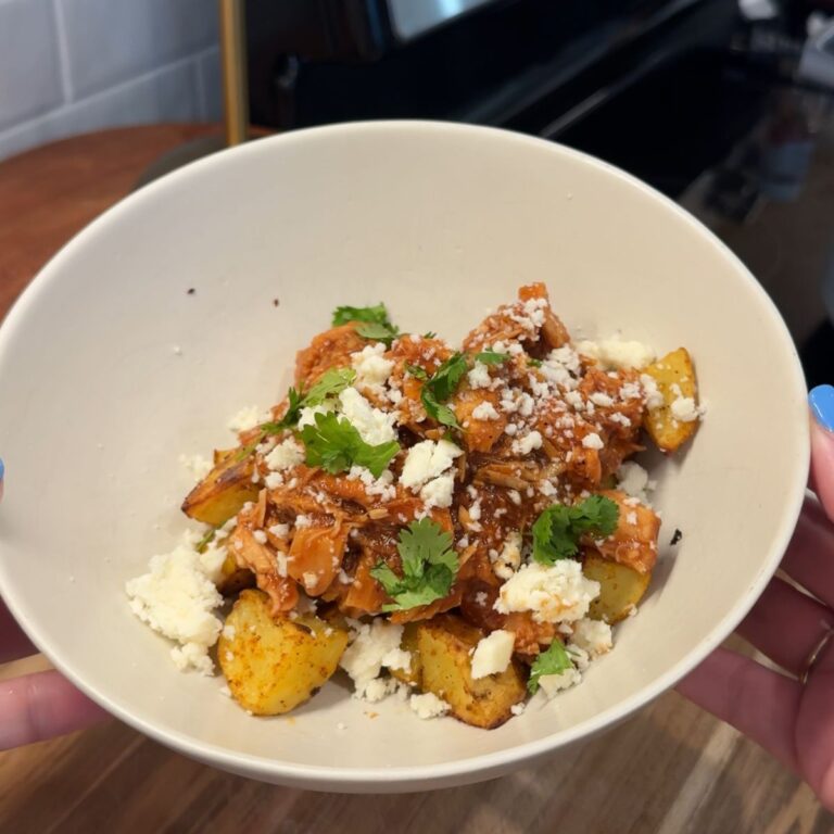 crockpot honey chipotle bbq chicken in bowl with cheese and cilantro on top