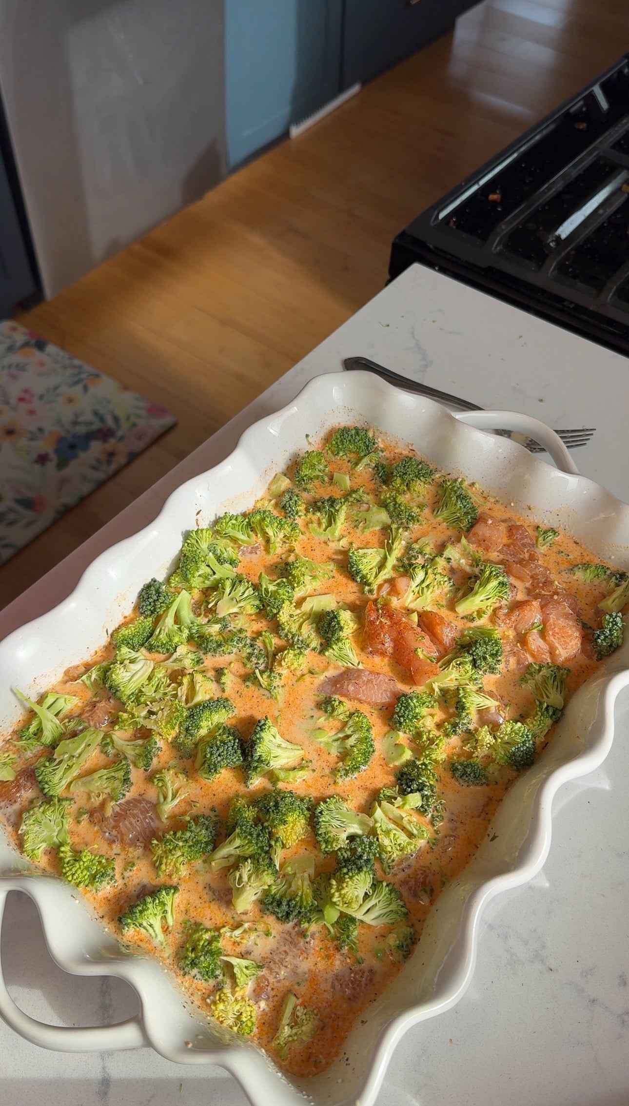 Marinated diced chicken, dry orzo, and finely diced broccoli added to the creamy sauce in a baking dish.