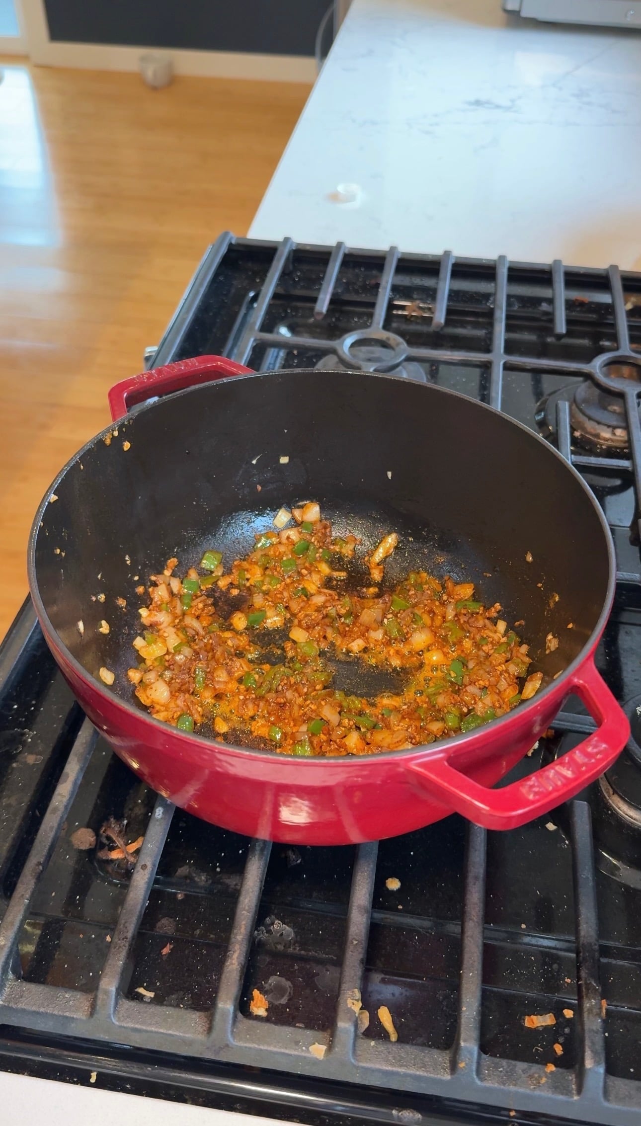 Diced onion and jalapeño sautéing in olive oil in a red Dutch oven for chicken tortilla soup.