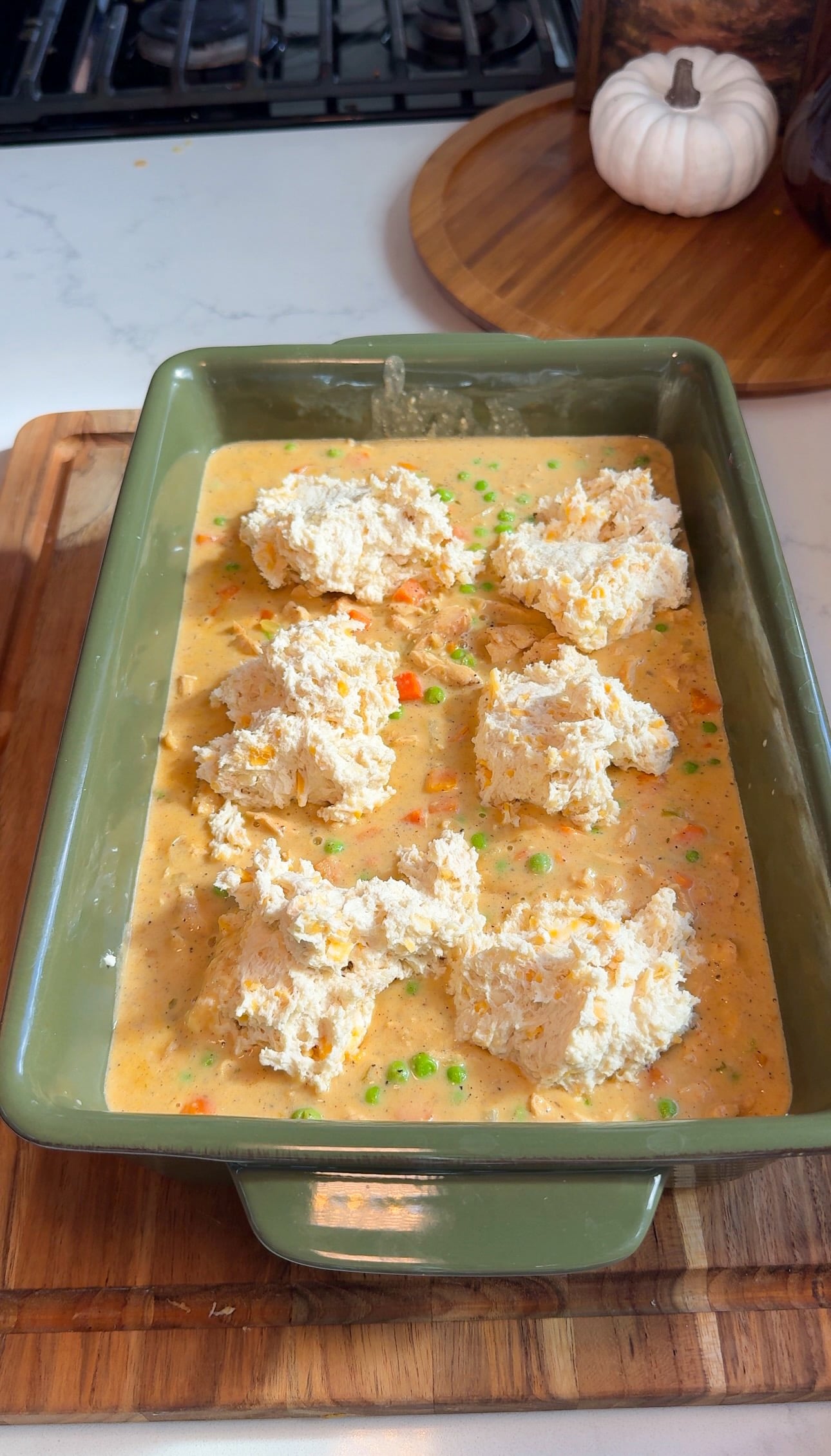 Scoops of Red Lobster cheddar bay biscuit dough on top of chicken pot pie filling before baking.